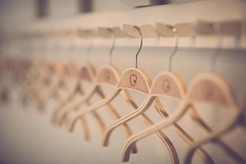 close up shot of clothing hangers inside a clothing cabinet.